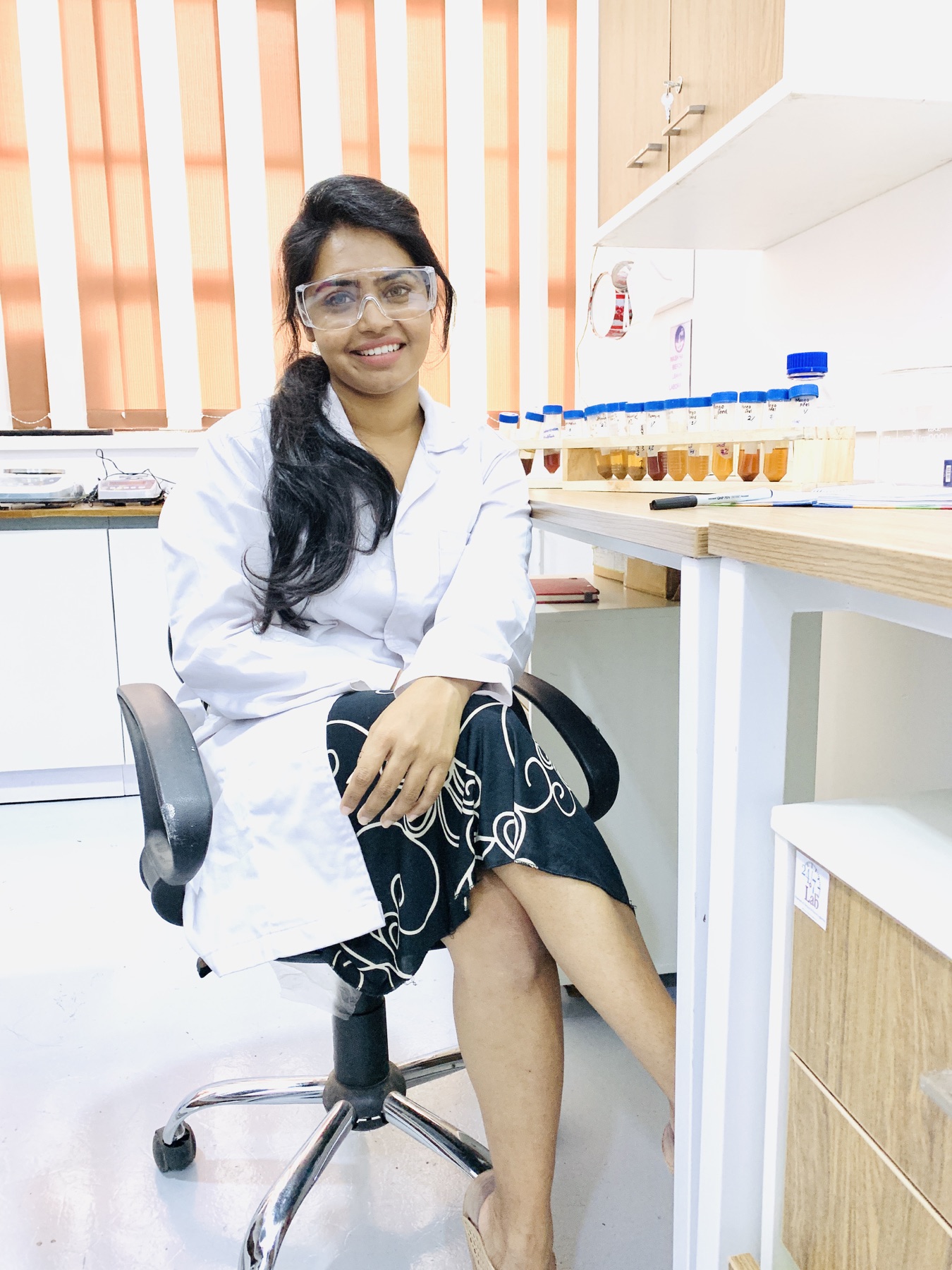 Sanali Jayalath in the laboratory beside prepared fruit-waste research samples